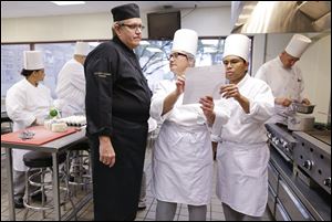 Chief instructor Larry Baumann, left, answers questions for students in a professional cook class at the Culinary Academy of Las Vegas.