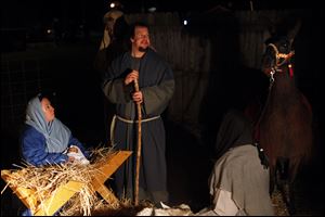 Kelly and Kyle Tarry portray Mary and Joseph in a live version of the Nativity during the fifth annual Christmas tree lighting ceremony at Strawberry Acre Park in Holland, Ohio. Area ministers, like their parishioners, spend time on Christmas with family members.