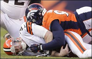 Cleveland Browns quarterback Brandon Weeden, left, is sacked by Broncos defensive end Elvis Dumervil in the third quarter Sunday in Denver. Weeden left the game after that play with a right shoulder injury and did not return. The Browns lost 34-12.