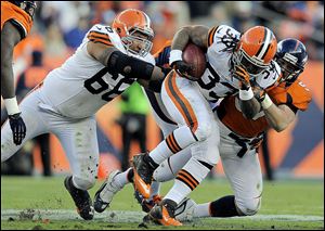 Browns running back Trent Richardson is tackled by Denver's Keith Brooking in the fourth quarter. Richardson later injured his ankle while pass-blocking for Colt McCoy.