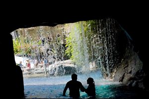 The Hyatt Regency Maui Resort & Spa pool offers an unusual swimming experience with waterfalls spilling over a cave leading to a children's water play area in Lahaina, Hawaii.