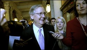 Senate Minority Leader Mitch McConnell of Ky. is pursued by reporters as he walks to a Republican policy luncheon Friday on Capitol Hill in Washington.