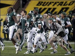 Michigan State players celebrate on the field after winning the Buffalo Wild Wings Bowl against TCU on Saturday in Tempe, Ariz.