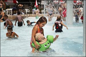 Margaret O'Neill, 6, center left, holds her brother Finnegan, 2, both of Sylvania, as the two swim at Burnham Park in Sylvania.