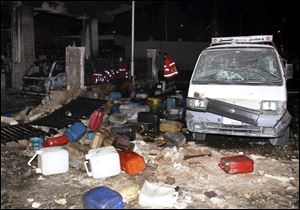 Syrian firefighters check a gas station that was attacked by a car bomb killing several people, activists said, in Damascus, Syria