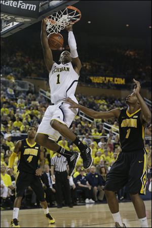 Michigan forward Glenn Robinson III dunks over Iowa forward Melsahn Basabe during the second half Sunday at Crisler Arena in Ann Arbor. With a 95-67 win over Iowa, second-ranked UM continued its best start since 1986.