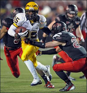 Kent State tailback Julian Durden, left, evades Arkansas State’s Cole Lorigan during the GoDaddy.com Bowl on Sunday.