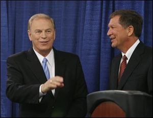 Former Ohio Gov. Ted Strickland, left, and current Gov. John Kasich acknowledge supporters following their debate at the University of Toledo in October, 2010.