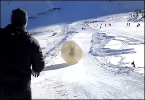 Denis Burakov and another man are seen inside a large plastic ball called a zorb last Thursday as they roll down a hill beore tragedy struck at the winter sports venue at Dombai in the Caucasus Mountains of southern Russia.  What was supposed to be a thrilling ride down a ski slope inside a giant inflatable ball has ended in tragedy when the zorb veered off course and sailed over a cliff, killing Denis Burakov and leaving the other man badly injured. 