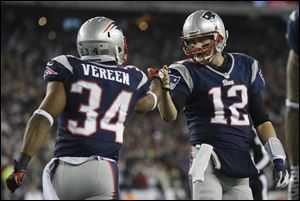 New England Patriots running back Shane Vereen, left, is congratulated by quarterback Tom Brady after Vareen's eight-yard touchdown reception Sunday in Foxborough, Mass. Brady got his 17th playoff win, the most for any quarterback, in New England's 41-28 AFC divisional victory over Houston on Sunday.