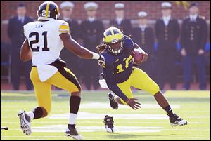 Michigan quarterback Denard Robinson loses his shoe as he runs for a first down last fall against Iowa.