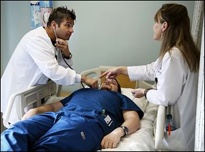 Owens Community College nursing students Jamie Swerlein, left, and Wade Niederkohr, center, work in the lab with instructor Debbie Sullivan, right.