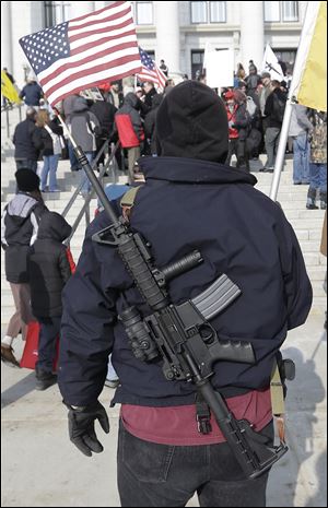 Gun-rights advocate Nate Rodriguez, of West Valley City, Utah, carries his AR-15 with a U.S. flag in the barrel today outside the Utah Capitol during the national Gun Appreciation Day Rally in Salt Lake City.