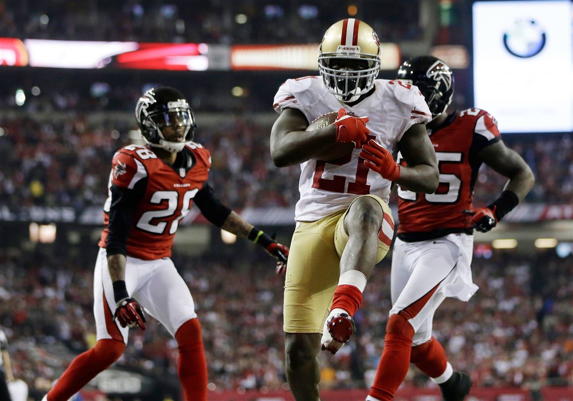 San Francisco 49ers Frank Gore (centre) breaks through the Denver