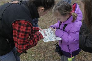 Kate Zimmerman and Grace Korte, 5, work together to identify a bird.