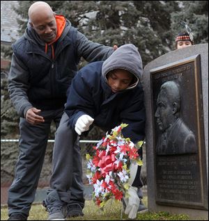 Frankie West, left, watches Amadeus Cannon, right, lay a wreath today at a memorial during the Martin Luther King Civil Rights Movement March at Martin Luther King Park in Bethlehem, Pa. 