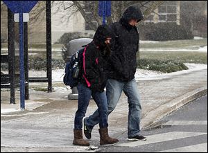 Sophomores Taylor Juza, left, and Kyle Mauter are bundled up against single-digit temperatures as they cross the University of Toledo campus on Tuesday.