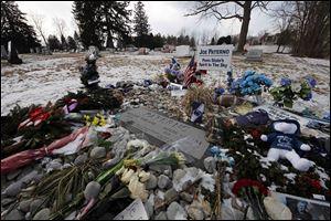 Momentos surround the headstone at the grave of former Penn State head football coach Joe Paterno as supporters of Paterno mark the 1-year anniversary of his death with a candlelight vigil Tuesday night. 