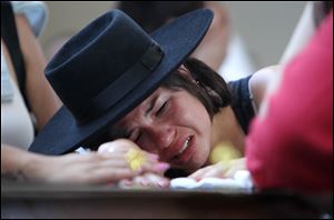 A woman cries over the coffin of  her boyfriend at a gymnasium where bodies were brought for identification in Santa Maria city, Rio Grande do Sul state, Brazil, Sunday.