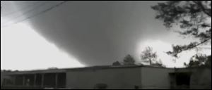 In this image made from video and released by WSB TV in Atlanta, a tornado moves through the town of Adairsville, Ga. Today.