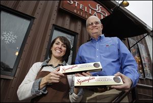 Nancy Bontrager and Dean L. Spangler of the Spangler Candy Co., with boxes of hand crafted peanut clusters she is making for the company at her Stella Leona artisan chocolates in Pettisville.