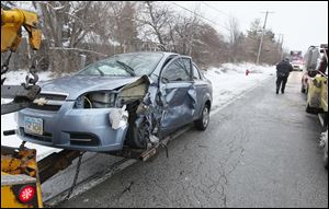 One of the damaged vehicles is removed from the 4700 block of South Avenue in Toledo, following a crash early today.