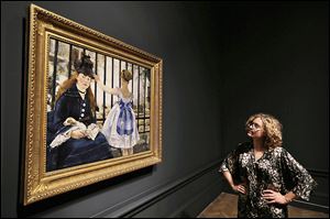 A Royal Academy of Arts employee examines Manet’s ‘The Railway, 1873’ at the gallery in  London.