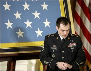 Medal of Honor recipient, retired Staff Sgt. Clinton Romesha, lowers his head today as President Barack Obama speaks about the soldiers lost during an attack on Combat Outpost Keating.