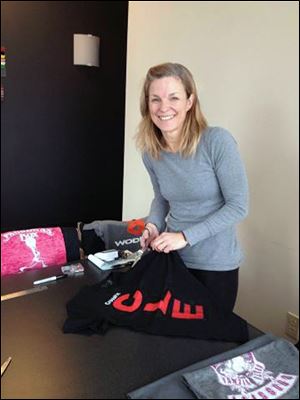 Beth White, a Crossfit trainer for Comet Crossfit, helps cut patches for the Joe Lengel tribute quilt. 