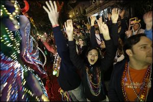 Revelers yell for beads and trinkets during the Krewe of Orpheus Mardi Gras parade in New Orleans, Monday.