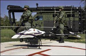 This photo provided by Vanguard Defense Industries, shows a ShadowHawk drone with Montgomery County, Texas, SWAT team members, September, 2011.