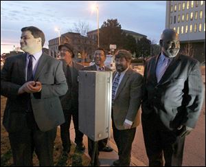 Toledo City Council President Joe McNamara, left,  and Mayor Mike Bell, right,  flip a switch on holiday lights last December. The two men are running for mayor this year.