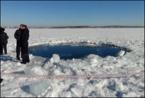 A circular hole in the ice of Chebarkul Lake where a meteor reportedly struck the lake near Chelyabinsk, about 930 miles east of Moscow,  Russia.