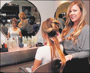 Stylist Nicole Cascadden inserts the first of five rows of length hair extensions for Giselle Veller at Salon Hazelton in Perrysburg, Ohio. Nicole herself is wearing length and body hair extensions.