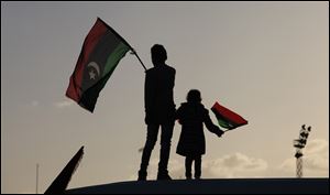 Libyan children wave national flags as they look out over Tahrir Square in Benghazi during a celebration. People used fireworks and sent balloons in the sky.