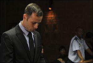 Olympic athlete Oscar Pistorius stands inside the court as a police officer looks on during his bail hearing at the magistrate court in Pretoria, South Africa, today.