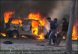 This photo released by the Syrian official news agency SANA, shows Syrian security agents carrying a body following a huge explosion that shook central Damascus, Syria.