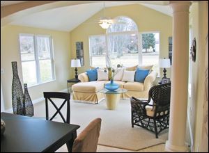 An archway supported by pillars defines the opening to this delightful sunroom.