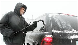 Jock Williams scrapes ice off of his windshield downtown. A thin but stubborn layer coated many vehicles. But it was the first time in weeks that many local drivers needed to spend much time scraping ice.