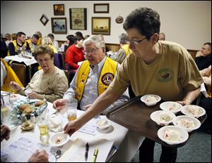 Julie Delrue serves dessert to Bedford Lions Club members  during a meeting Wednesday at the Erie Restaurant in Erie. The club meets at the restaurant twice a month.