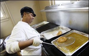 Linda Cross fries fish during the fish fry at Bethel Apostolic Church on W. Bancroft Street in Toledo. The church offers carryout meals as part of its fish fries that are served on the first and third Fridays of each month at its Time Square dinner theater.