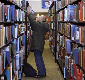 Toledoan Charles Fasnaugh chooses a book at the Lucas County Toledo main library in Toledo.