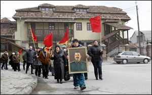 Georgians carry a portrait of former Soviet dictator Joseph Stalin and red flags during a ceremony marking the 60th anniversary of Stalin's death in his home town of Gori, about 50 miles west of the Georgian capital Tbilisi.