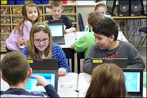 Third graders including Raylynn Nocella, left, and Kane Townsend, right, compete online against students from around the world during the World Education Games. Students at Monroe Road Elementary are participating in the three-day competition.