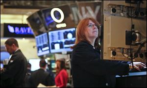 FILE - In this Feb. 20, 2013, file photo, Maureen Smaldone, a trader for Brendan E. Cryan and Company, monitors trading activity from her workstation at the New York Stock Exchange. The positive mood in financial markets showed few signs of abating Thursday March 7, 2013 ahead of policy statements from Europe's top two central banks. (AP Photo/Bebeto Matthews, File)