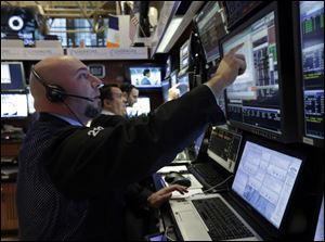 Traders work in their booth on the floor of the New York Stock Exchange Friday, March 8, 2013. Stocks are opening higher on Wall Street after the government reported a burst of hiring last month that sent the unemployment rate to a four-year low. (AP Photo/Richard Drew)