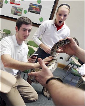 Samantha Burkholder reacts as classmate Mitch Cochell feels a ball python snake.