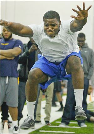 Toledo's T.J. Fatinikun, a Perrysburg graduate, performs the broad jump during Pro Day for senior football players at UT's Fetterman Training Center.