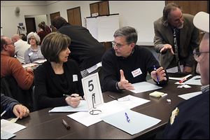 Robin Whitney, left, Toledo’s public utilities commissioner of engineering services, talks with John Clement of West Toledo during the first public forum to review street planning and address residents’ questions and concerns. They met at the Sanger branch of the Toledo-Lucas County Public Library.