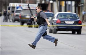 Law enforcement officers run for cover along Main Street  in Herkimer, N.Y., when shots were fired while they were searching for a suspect in two shootings that killed four and injured at least two on, Wednesday, March 13, 2013. 